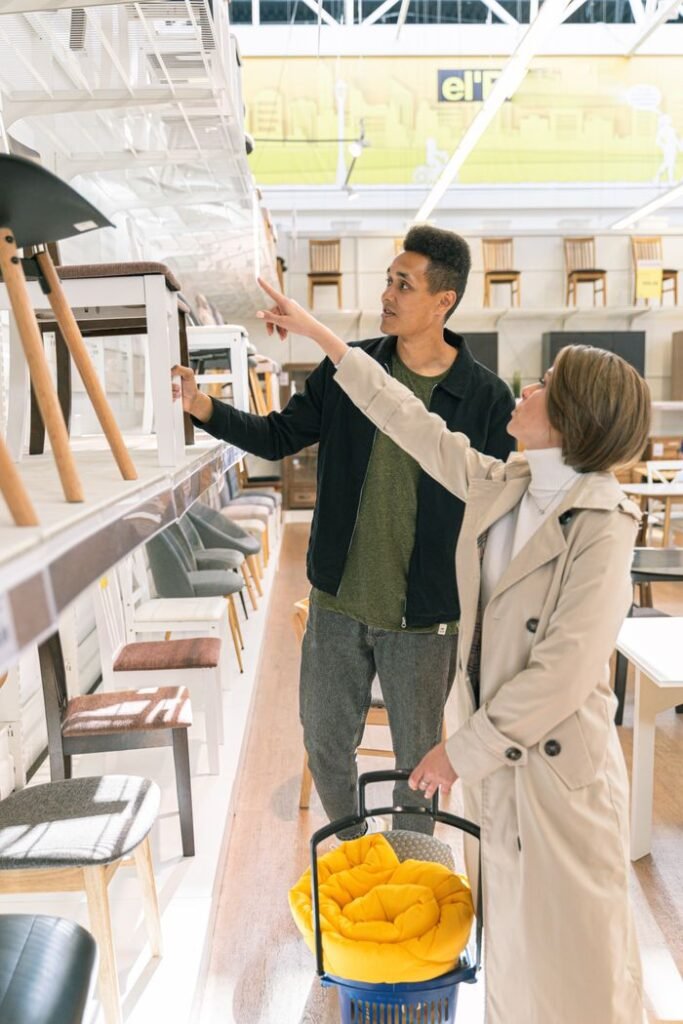 A couple shopping for furniture in a brightly lit store, discussing options.